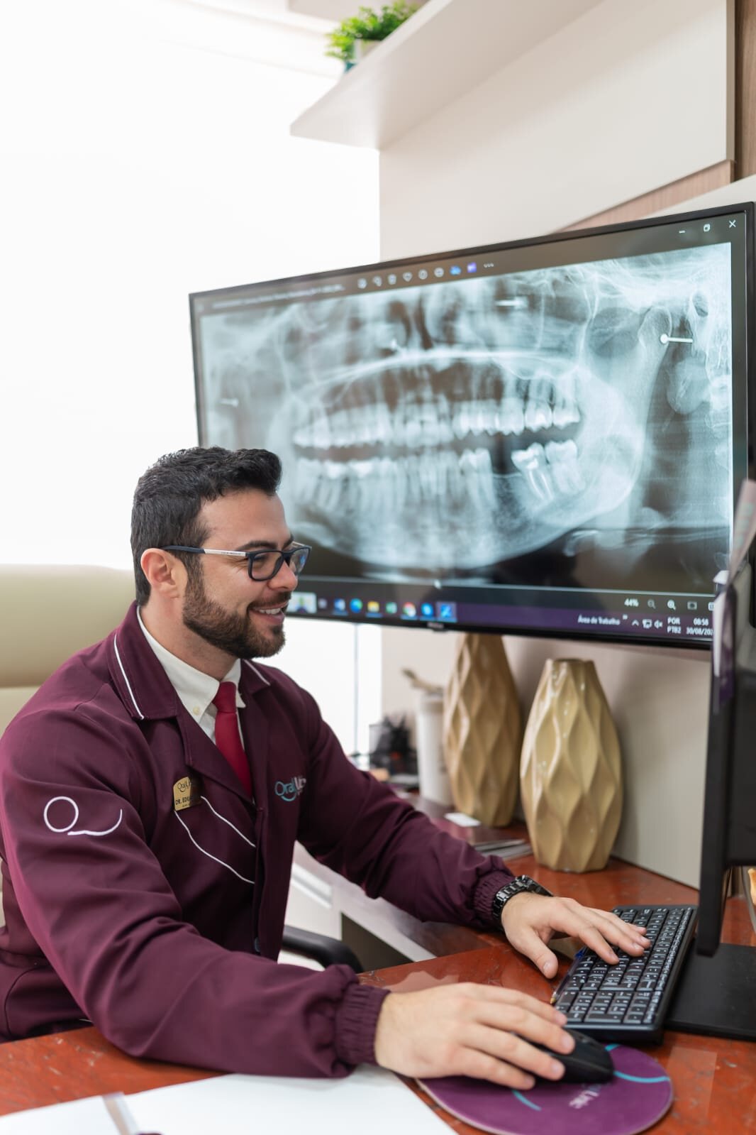 Dr. Eduardo Perlin analisando a radiografia panorâmica de um paciente na Oral Unic Osório